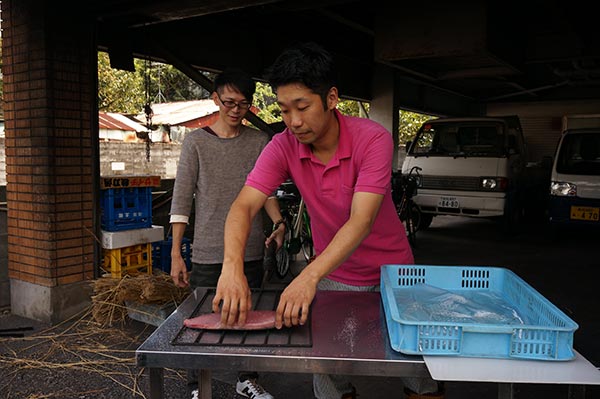 カツオのタタキ藁焼き体験：網にカツオを乗せます。