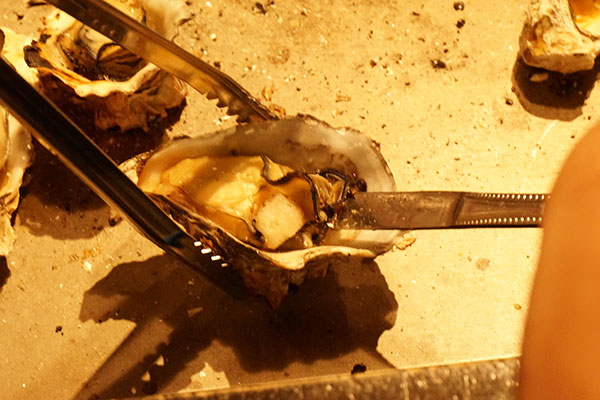 かき焼き てっぱんで牡蠣の貝柱を取る